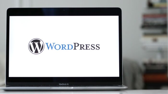 WordPress logo prikazan je na ekranu laptopa u radnom prostoru