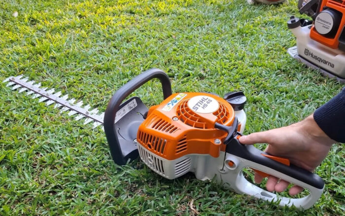 Električne makaze za živu ogradu na zelenoj travi