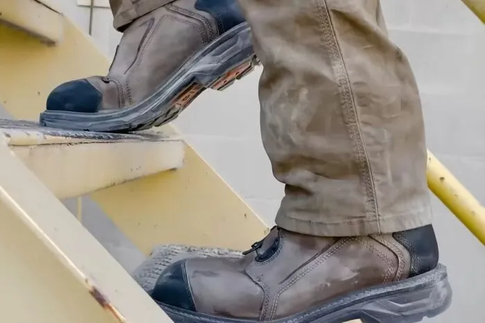 Muškarac nosi radne cipele dok se penje uz stepenice
