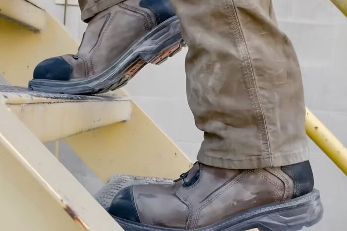 Muškarac nosi radne cipele dok se penje uz stepenice