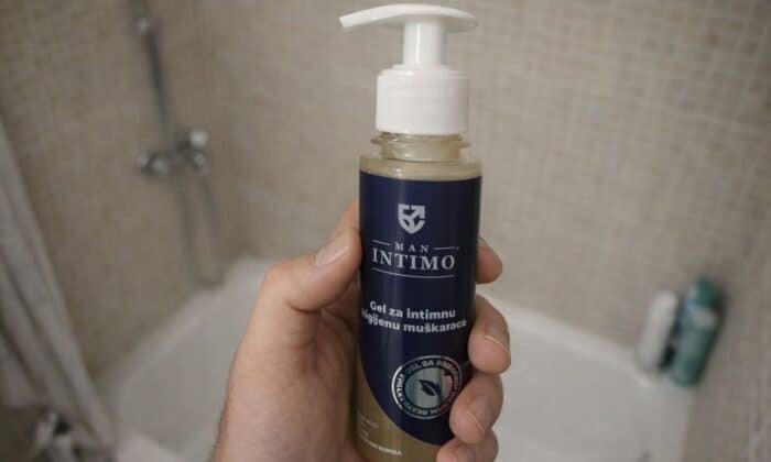 momak drži m an intimo gel u ruci u kupatilu