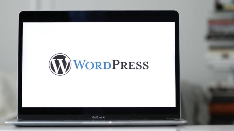Laptop sa prikazanim WordPress logotipom na ekranu, simbol izrade web sajta u WordPressu