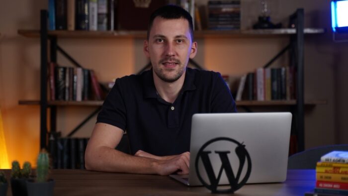 Aleksandar Đekić sedi za laptopom pored WordPress znaka u radnom prostoru