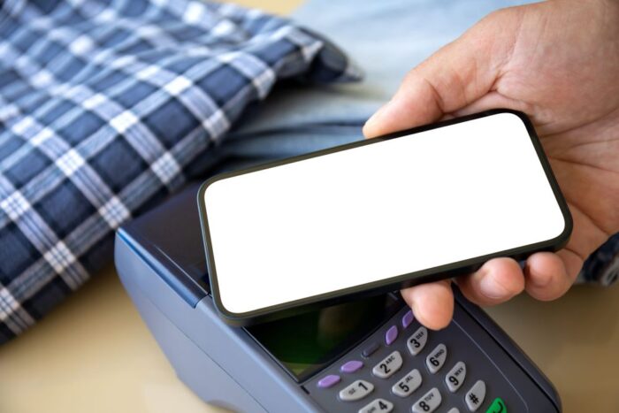 Osoba prislanja mobilni telefon uz POS terminal radi beskontaktnog plaćanja.